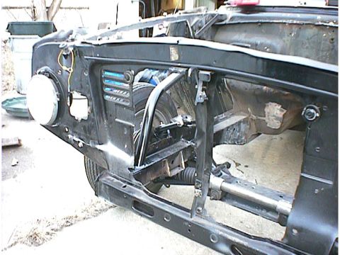 1960 Ford Falcon - The front section of a 1960 Ford Falcon is visible, revealing its chassis and suspension details.