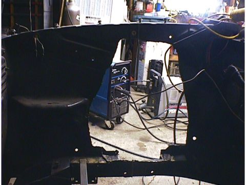 1960 Ford Falcon - A car's frame is visible in a workshop setting, with welding equipment nearby.