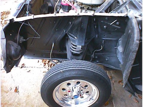 1960 Ford Falcon - The front wheel and suspension components are visible in this close-up of a car's engine bay.