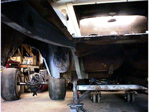 1960 Ford Falcon - The rear axle and frame of a vehicle are visible, supported by stands in a workshop setting that appears to be a workshop.