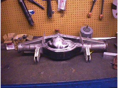 1960 Ford Falcon - A custom rear axle assembly is shown on a workbench, with tools hanging on the pegboard behind it.