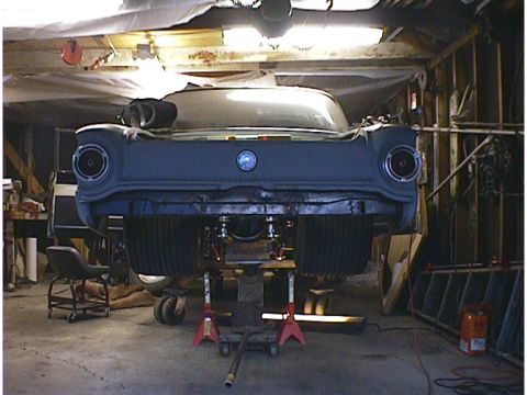 1960 Ford Falcon - The rear of a 1960 Ford Falcon is visible, supported by jack stands in a workshop setting.