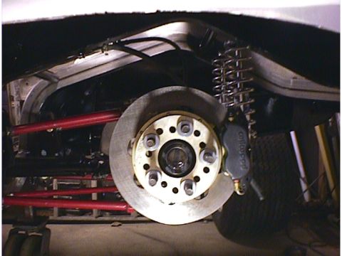 1960 Ford Falcon - Close-up view of a vehicle's rear suspension and brake system, showing a disc brake and coilover shock.