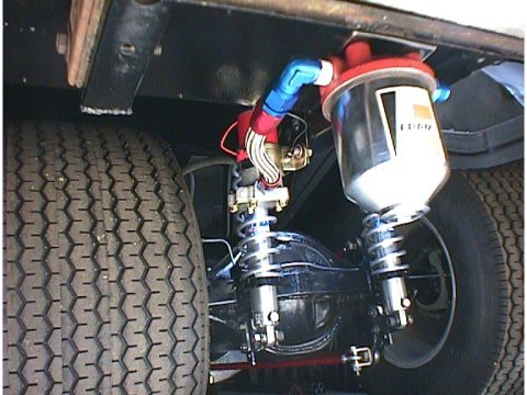 1960 Ford Falcon - Close-up of aftermarket fuel filter and suspension parts on a vehicle's rear end.