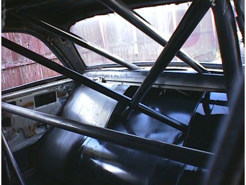 1960 Ford Falcon - The interior of a 1960 Ford Falcon shows a custom roll cage and black upholstery, suggesting a racing or performance modification.