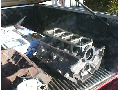 1960 Ford Falcon - Engine block and other parts loaded in the bed of a pickup truck.