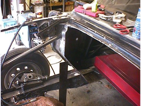 1960 Ford Falcon - Close-up view of a car's frame and wheel well, showing suspension parts and structural elements.