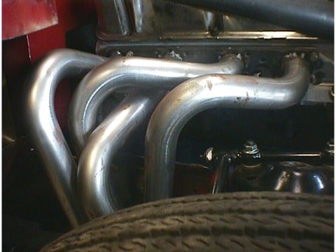 1960 Ford Falcon - The chrome exhaust manifold and pipes are a prominent feature in this engine bay detail shot.