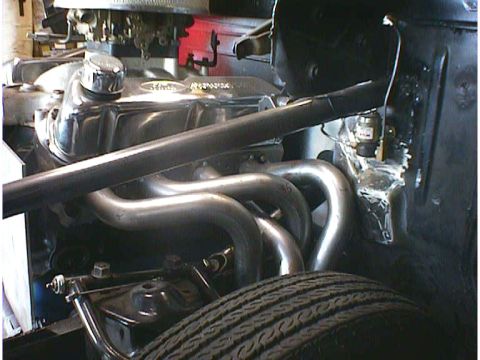 1960 Ford Falcon - Custom exhaust headers installed on a V8 engine, with a tire visible in the foreground.