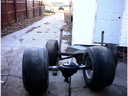 1960 Ford Falcon - Rear axle assembly with large drag racing tires is shown in a driveway.
