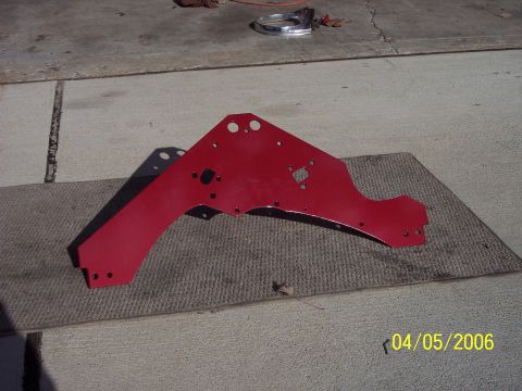 1960 Ford Falcon - A red painted metal bracket is shown on a mat, with a chrome trim piece visible in the background.