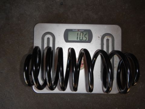 2003 Ford Crown Victoria - Photograph of a coil spring being weighed on a scale, not a technical document.