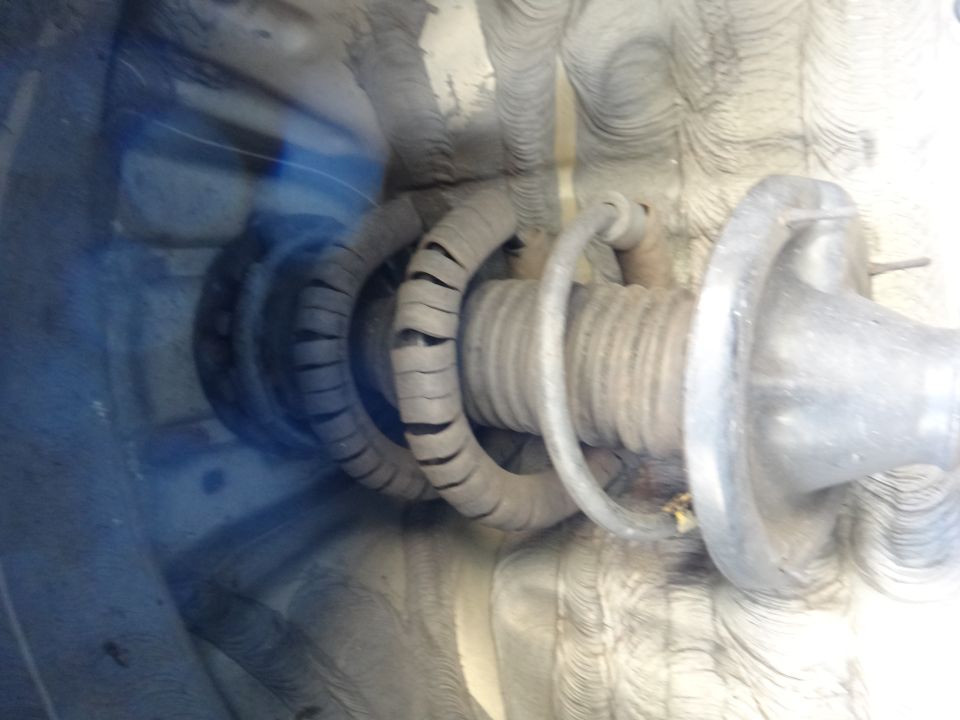 Close-up of a car's coil spring and strut assembly.