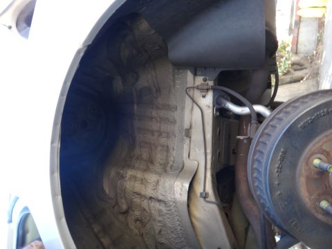 2003 Ford Taurus - Undercarriage view of a vehicle's wheel well and suspension system, including brake components.