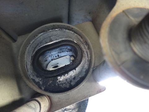 2003 Ford Taurus - Worn strut mount bushing showing deterioration of rubber and metal parts.