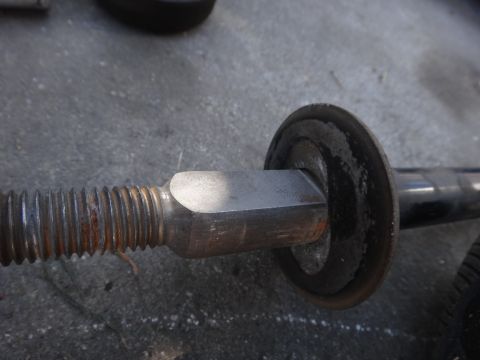2003 Ford Taurus - Close-up of a vehicle strut assembly, showing the threaded rod and a rubber bushing.