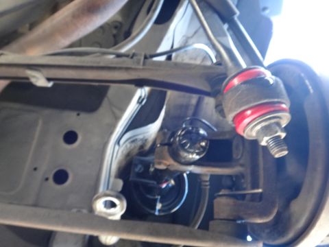 2003 Ford Taurus - Underside view of a vehicle's suspension system, focusing on a ball joint assembly.