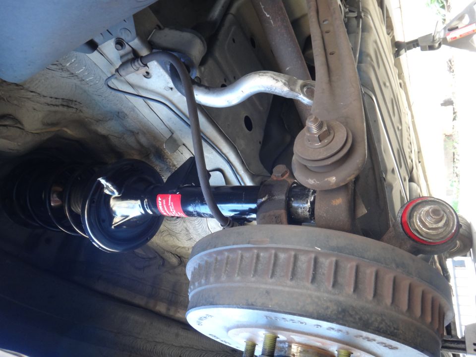 Rear suspension strut with red and black markings and drum brake assembly