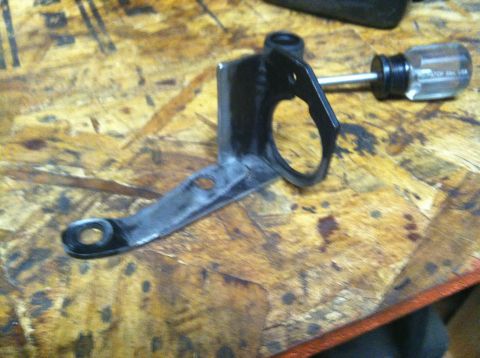 1975 Ford Courier - A metal bracket and a screwdriver are on a wooden surface.