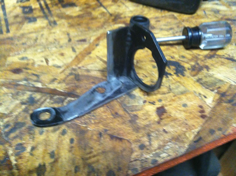 Metal bracket with a small screwdriver inserted into a hole