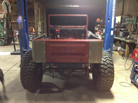 1985 Jeep CJ7 - This Jeep CJ-series body is on a lift, revealing its rear end and large off-road tires.