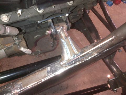 1985 Jeep CJ7 - Custom fabrication work on a vehicle chassis, showing welded joints and engine mounting hardware.