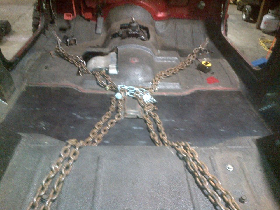 vehicle interior with floor removed and chains attached to frame