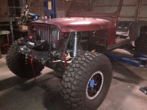 1985 Jeep CJ7 - This modified Jeep CJ-series features oversized tires and a winch, suggesting it's being prepped for off-road use.