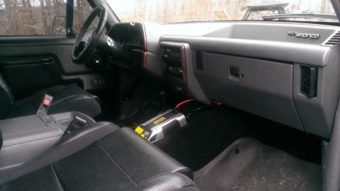 1988 Ford Bronco - The interior of a Ford Bronco, the dashboard and front seats, with an XLT Bronco badge visible.