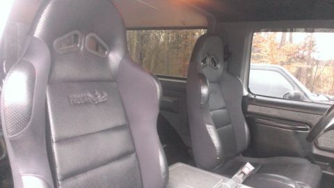 1988 Ford Bronco - The interior of a 1988 Ford Bronco shows two racing seats and a center console.