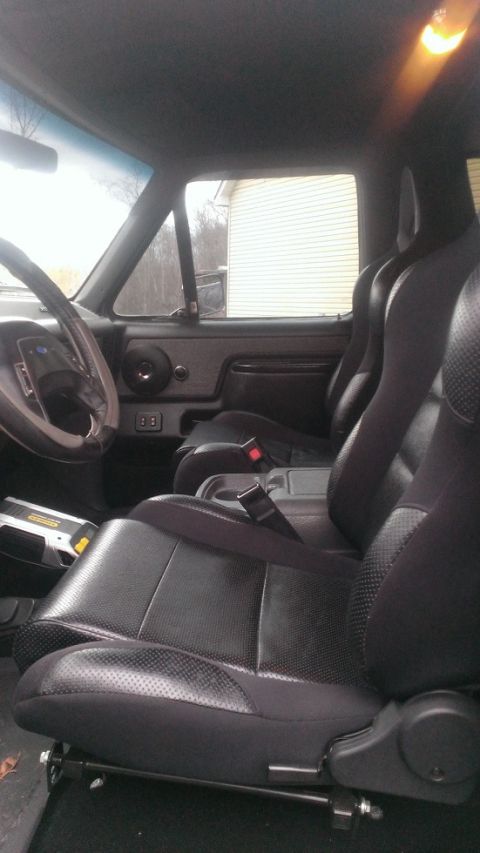 1988 Ford Bronco - The interior of a vehicle is shown, black leather seats and a steering wheel. The registry claims it is a 1988 Ford Bronco, but this cannot…