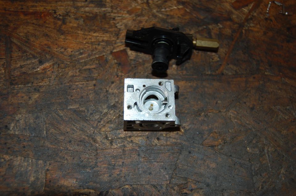 Carburetor body and fuel solenoid assembly on a wooden surface