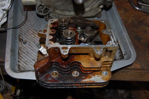 2006 Honda RANCHER - Close-up view of an engine cylinder head, revealing its internal components like valves and springs, with a spark plug still attached.