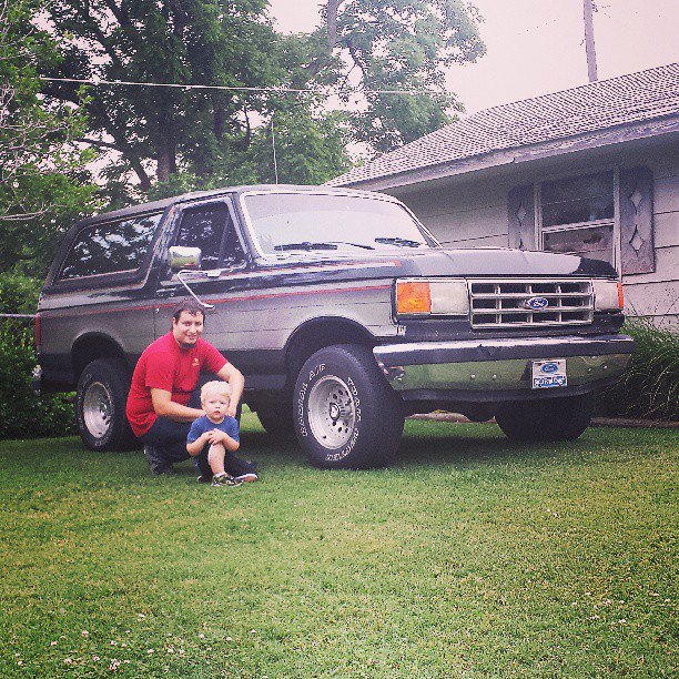 1987 Ford Bronco with two people in front yard