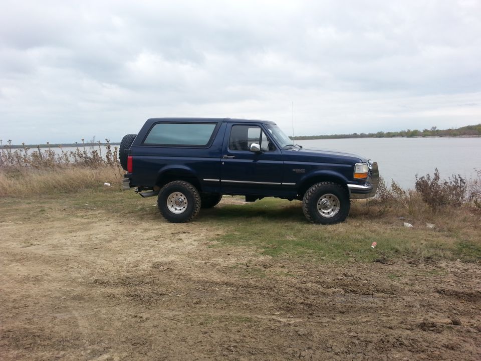 1995 Ford Bronco side view, dark blue, parked by water