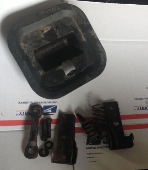 1993 Ford Bronco - Several used car parts, including a rubber boot and metal components, are laid out on a shipping box.