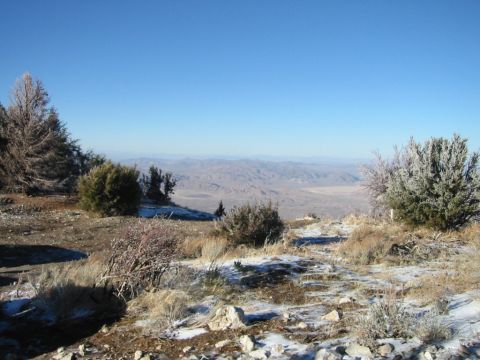 1985 Ford Bronco - A vast desert valley stretches out below a snow-dusted hillside on a clear day.