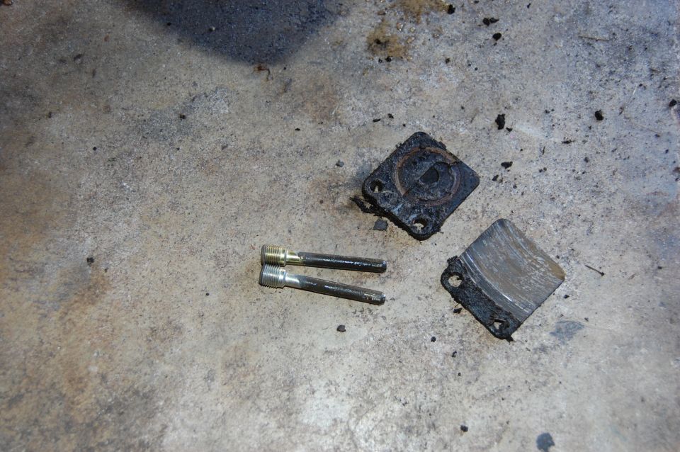 Brake caliper parts and pins on concrete floor