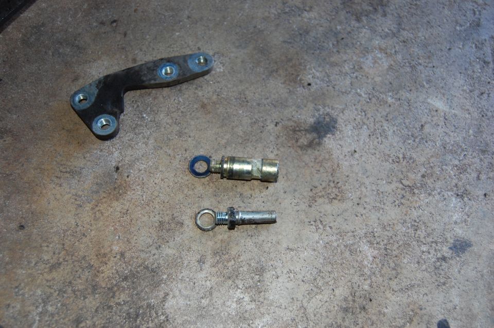 Metal bracket and two eye bolt-like parts on concrete