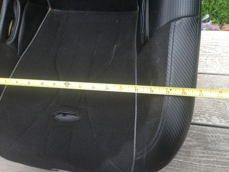 Close-up of a black car seat with a yellow measuring tape across it