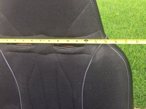1986 Ford Bronco - A yellow measuring tape is placed across a black car seat, showing measurements from 3 to 17 inches.