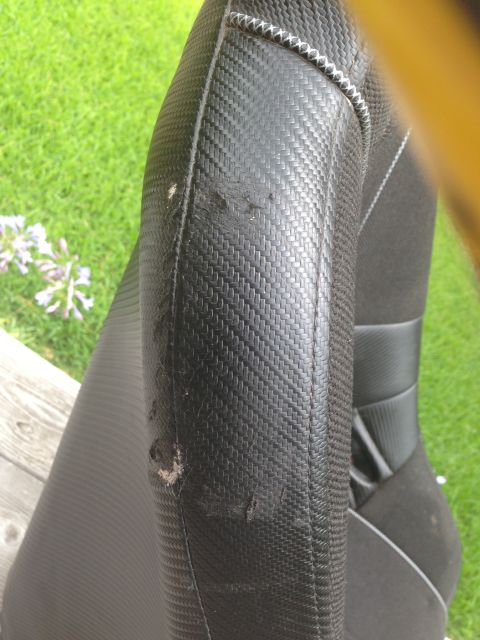 1986 Ford Bronco - Close-up of a worn car seat bolster, showing damage to the material.