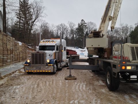 2003 Peterbilt 379 - A 2003 Peterbilt 379 truck is equipped with a crane, seen here in a snowy, outdoor setting.