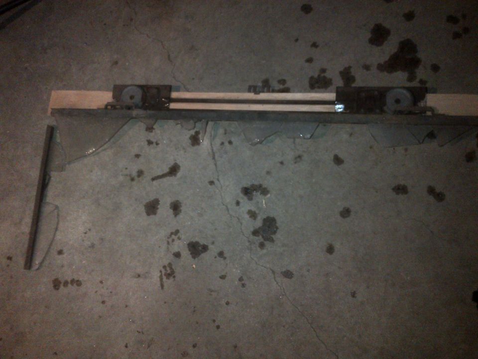 Wooden beam with metal rollers on a cracked concrete floor with oil stains