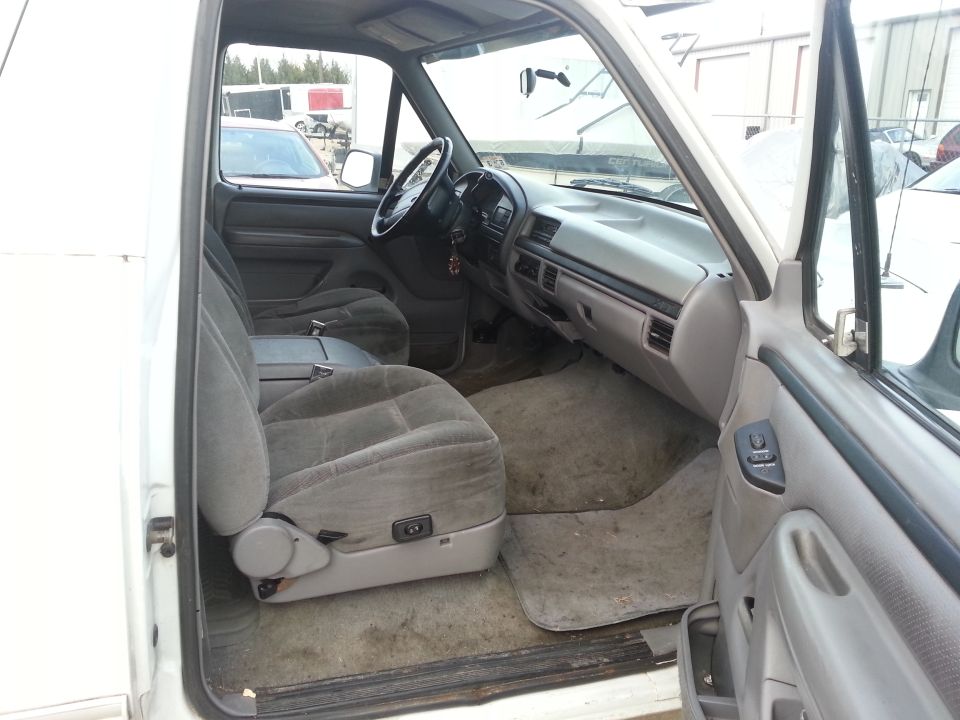 Interior view of a 1996 Ford Bronco showing front seats, dashboard, and door panel