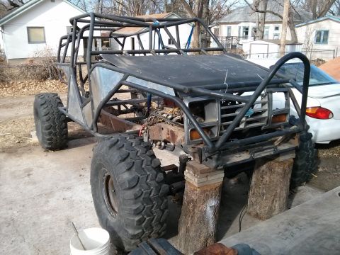 1986 Ford Bronco - This heavily modified vehicle features a custom roll cage and oversized tires, with its front end resembling an older truck.