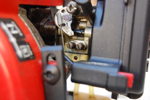 2006 Honda RANCHER - Detail of the carburetor linkage mechanism, showing screws and connecting wires.