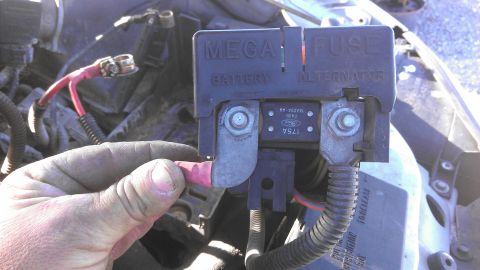 1990 Ford Bronco - Close-up of a vehicle's engine bay fuse box, showing electrical connections and labels.