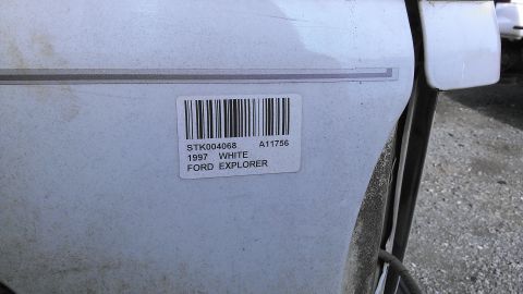 1990 Ford Bronco - A barcode sticker on a white vehicle door indicates it is a 1997 Ford Explorer, contradicting the registry's claim of a 1990 Ford Bronco.