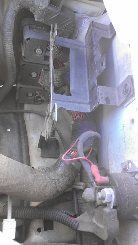 1990 Ford Bronco - Close-up view of engine bay wiring and starter motor components.